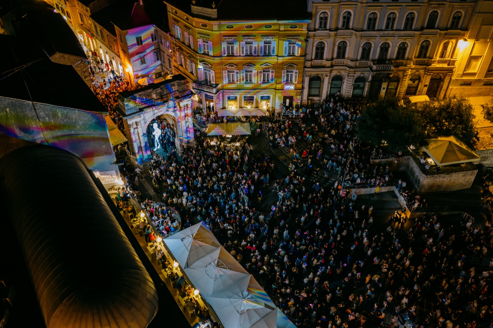 Pogled iz zraka na prepun Trg Portarata s projekcijama na slavoluku