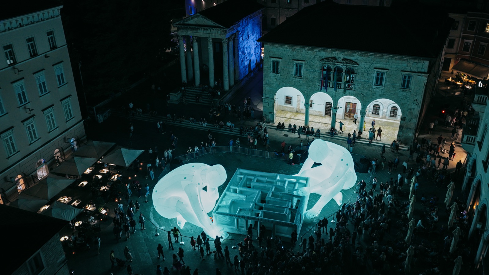 Dvije goleme svjetleće figure nad labirintom na Forumu, iz zraka